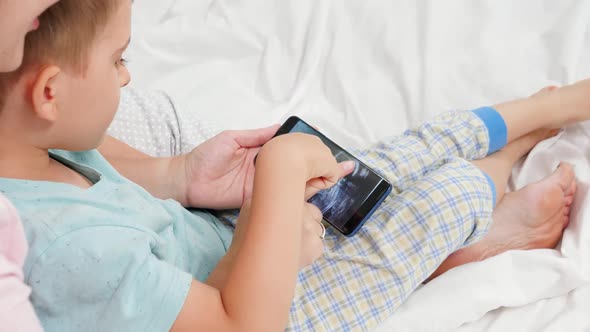 Closeup of Little Toddler Boy Looking on Ultrasound Image of His Unborn Baby Brother on Mothers