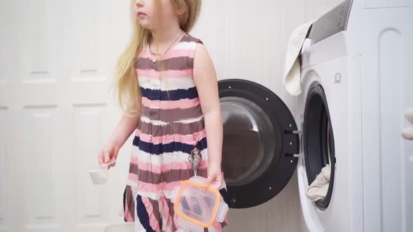 a Cute Little Girl Puts Washing Powder in the Washing Machine