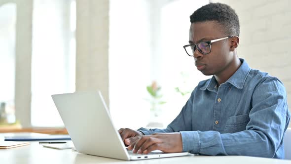 Young African Man with Laptop Shaking Head in Denial, No Sign 