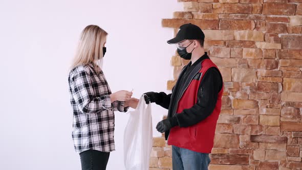 Delivery Man in a Protective Mask Is Giving an Order To a Woman