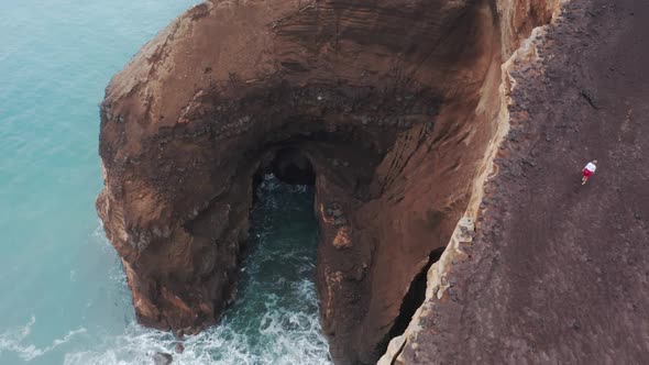 Tourist Explores Volcanic Island on Windy Day