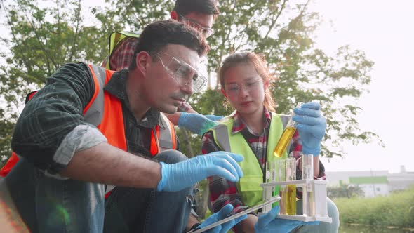 Scientist and assistants check contaminants in factory wastewater in a test tube