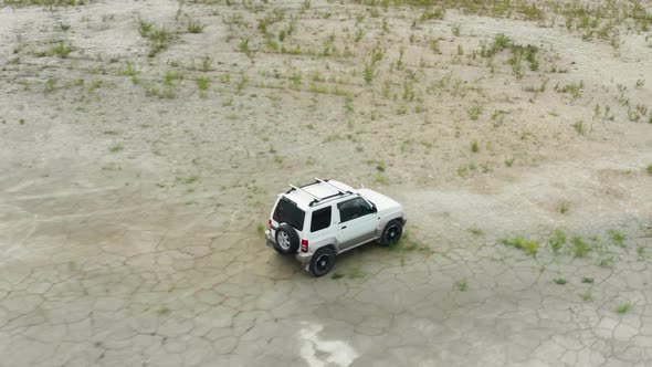 Aerial View of a Car Driving on Sand