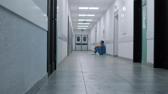Professional Medic Resting Alone in Hospital Corridor