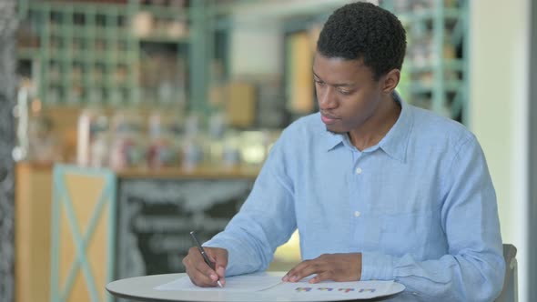 Professional Young African Man Reading Documents 