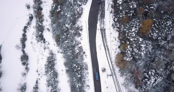 Zenital drone shot of a Volskwagen California driving through the mountain roads of the Pyrinees. Th