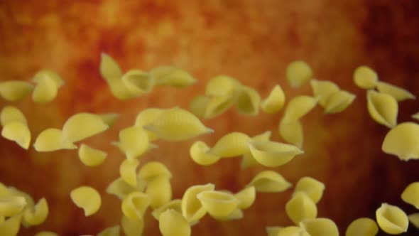 Pasta Conchiglie Rigate Flying and Rotating on a Yellow Ochre Background
