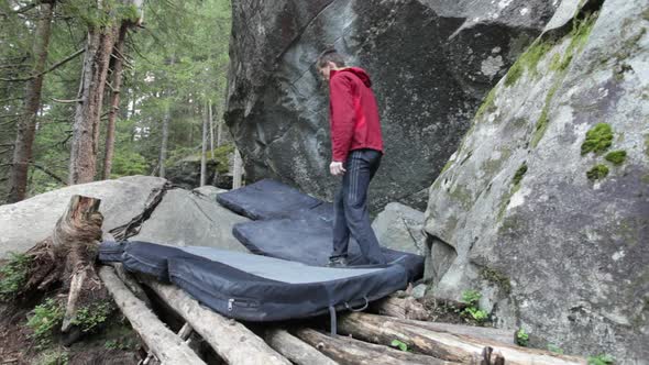 A man adjusting his pads before bouldering rock climbing up a mountain