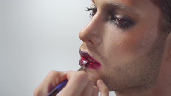 Applying Pink Lipstick on Male Model