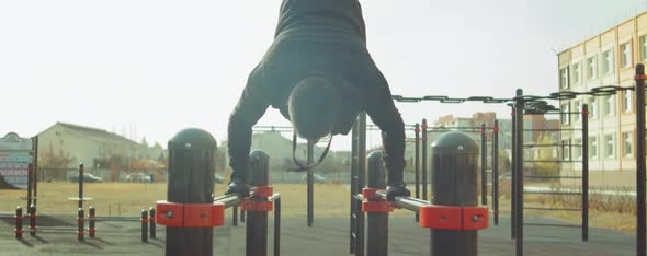 Man Doing Handstand on Parallel Bars Outdoor