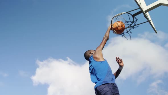 Basketball player scoring a dunk