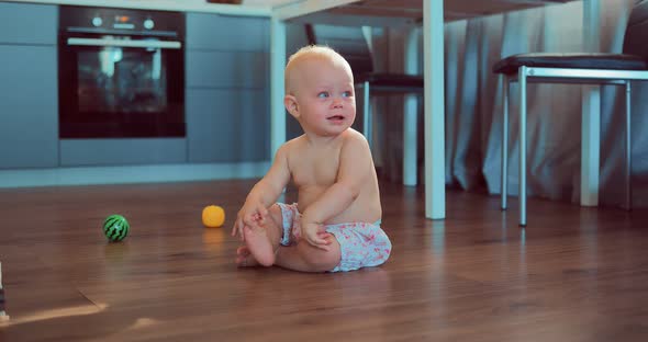 Crying Cute Little Girl Sitting on the Floor at Home