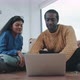 Close up of couple in their new flat sitting on the floor shopping online - VideoHive Item for Sale