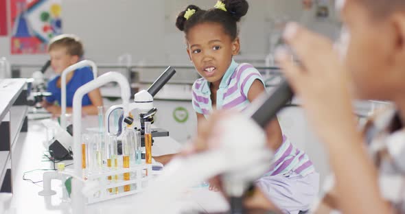 Video of happy african american girl with microscope during lesson alt