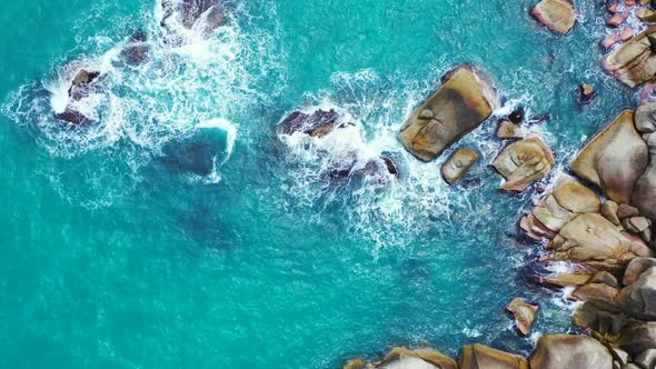 Aerial flying over landscape of tranquil shore beach break by blue lagoon with white sandy backgroun