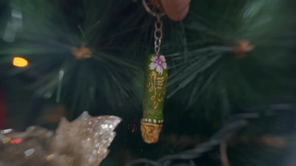 Green Wooden Keychain Painted With Floral Design Hanging On A Christmas Tree