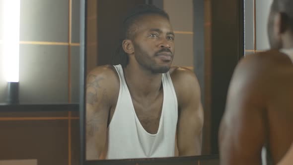 Reflection of Young African American Man Looking in Mirror and Thinking. Thoughtful Handsome Guy