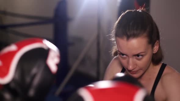 Female Boxer Trains with Trainer in Boxing Hall