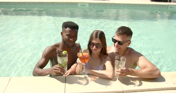 Multiracial Young Friends with Cocktails Chilling in Pool