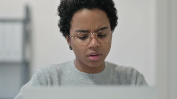 African Woman Thinking While Using Laptop