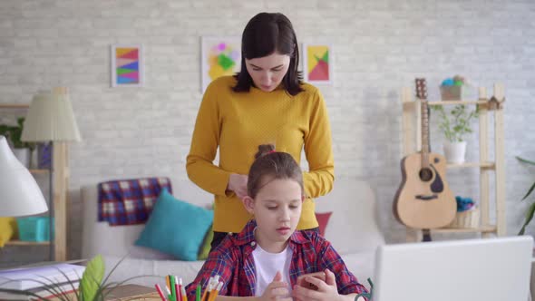 Mother Combs Her Daughter's Hair