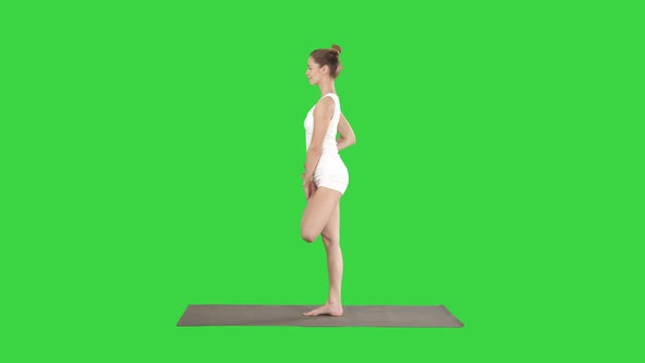Young Attractive Woman Practicing Yoga Doing Tree Exercise on a Green Screen, Chroma Key.