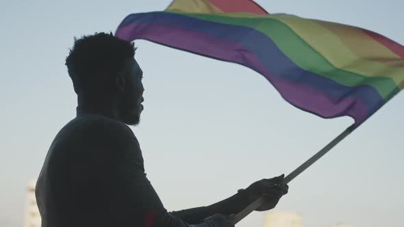 Black Man Waving Rainbow Flag. Sexual Identity and Equal Treatmant Concept