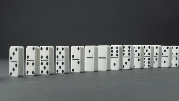 Domino Effect - a Series of Dominoes Falling Down the Chain Grayscale Image