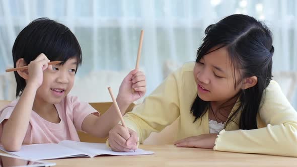 Asian Children Doing Homework Together