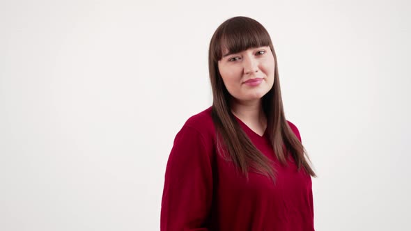 Proud and Confident Caucasian Brunette Woman in Winered Blouse Nodding at Camera Over White