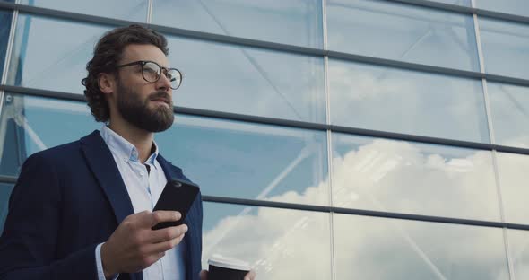 Handsome bearded Startup Businessman in Glasses using mobile Phone.