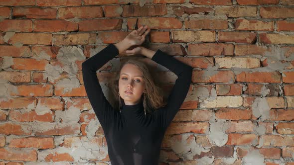 Young Woman Posing Against Brick Wall