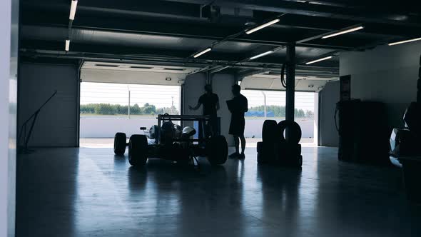 Workshop with Specialists Observing and Discussing a Racing Car