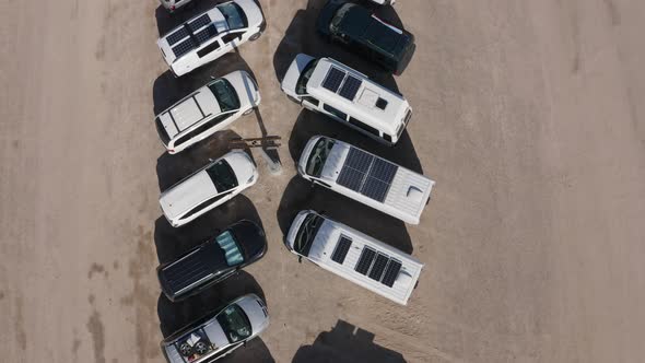 Aerial top-down view of a row of cars and trucks in the desert
