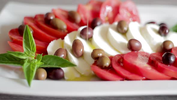 Pouring Oil on Italian Caprese