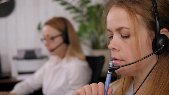 Closeup of a Woman Wearing a Headset in a Call Center Officetalking to a Client