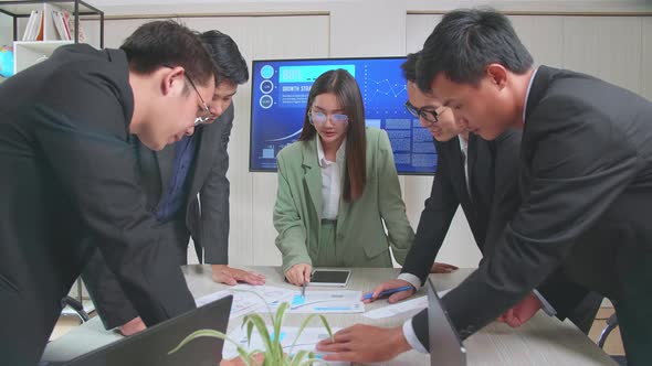 Meeting Room Asian Team Of Businesspeople Standing Around Table Having Strategic Planning Session