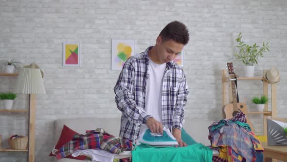 Young Asian Man Ironing Clothes on Ironing Board Close Up Slow Mo