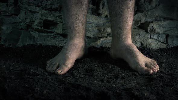 Barefoot Man Standing In Cave
