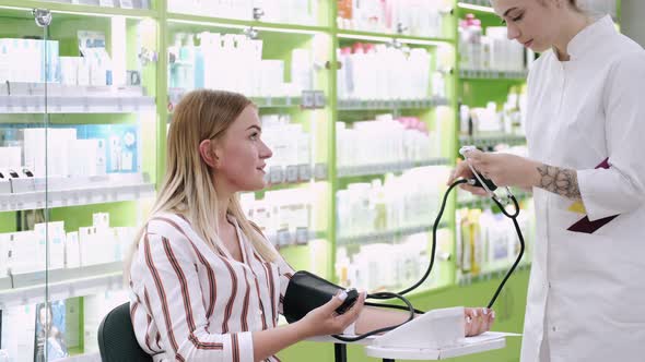 Pharmacist Checking Blood Pressure of Customer