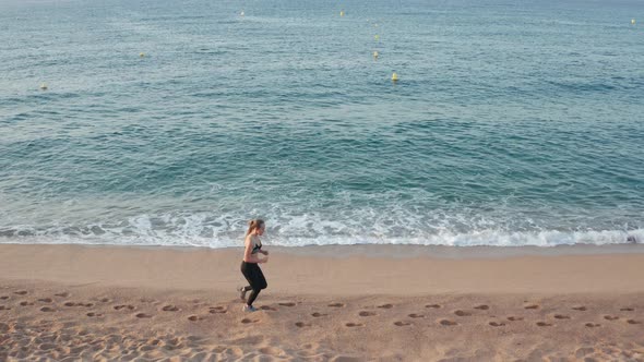 Drone View of Fit Woman Runner Training on Beach