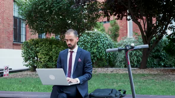 Businessman Working on the Laptop Outdoor, Slow Motion Zoom in