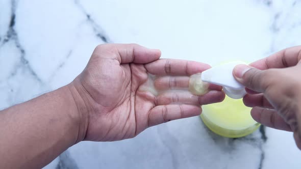 Young Man Washing Hand with Soap Bottle 