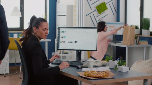 Businesswoman Having Lunchtime Eating Takeaway Delivery Pizza Slice at Desk in Company Office