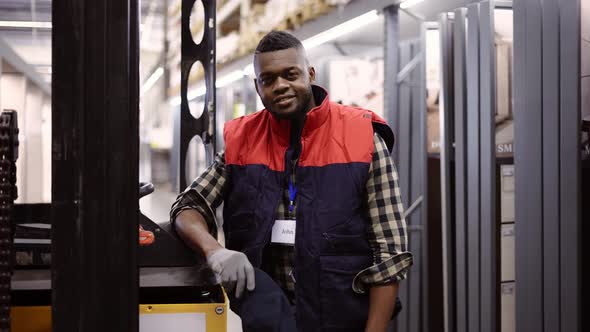 Close Up Portrait of Forklift Operator in the Warehouse Wearing Uniform and Badge