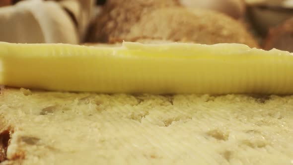 Closeup of Spreading Butter on Fresh Baked Piece of Bread