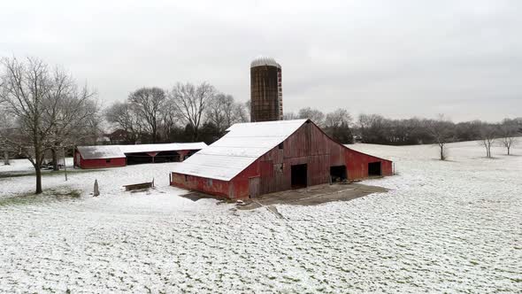 Flying Drone Shot of Red Hay Barn in the winter  Snow Middle  Tennessee