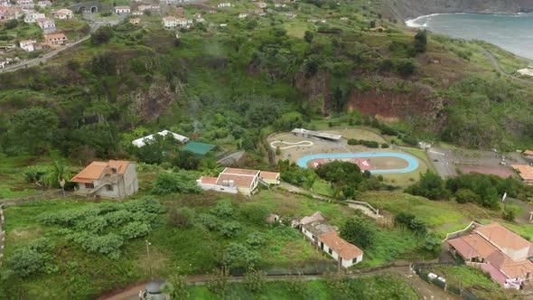 Aerial Footage of High Volcanic Hillsides with Coastal Cottages on Top