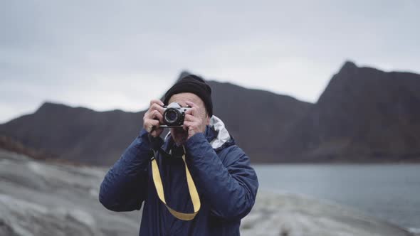 Hiker Focusing Slr Camera At Fjord