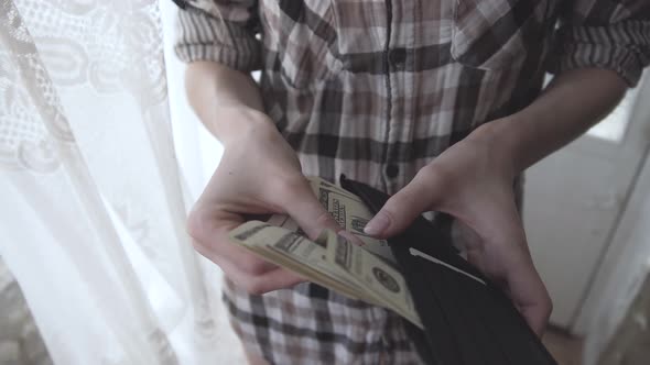 Woman takes money from a wallet